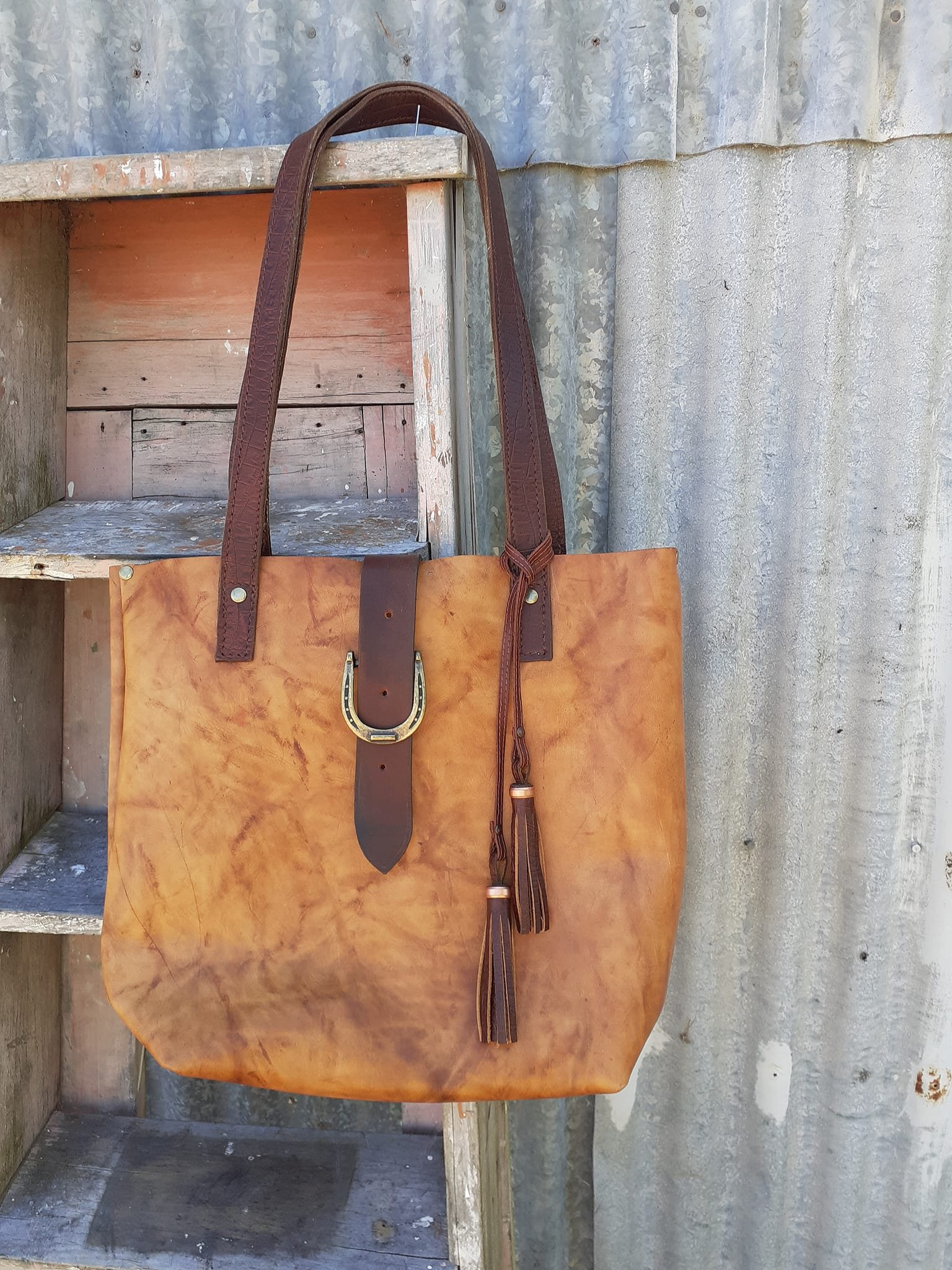 Leather tote bag, golden tan body with brown straps.